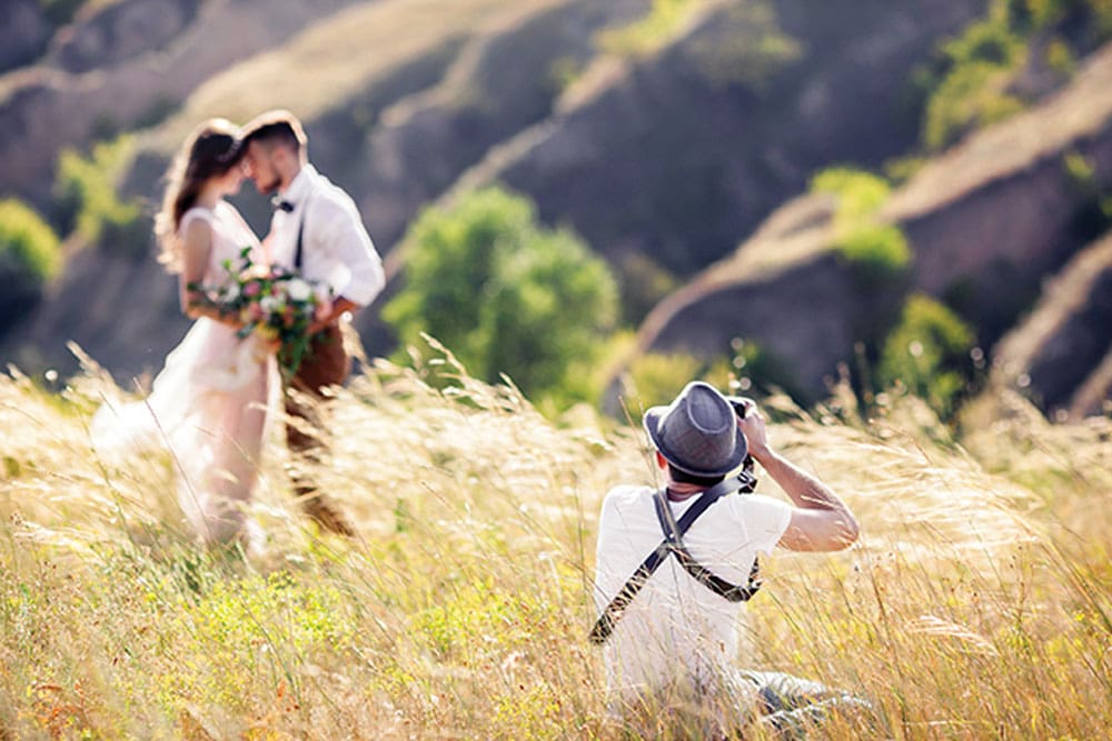 wedding photographer taking photo of wedding couple